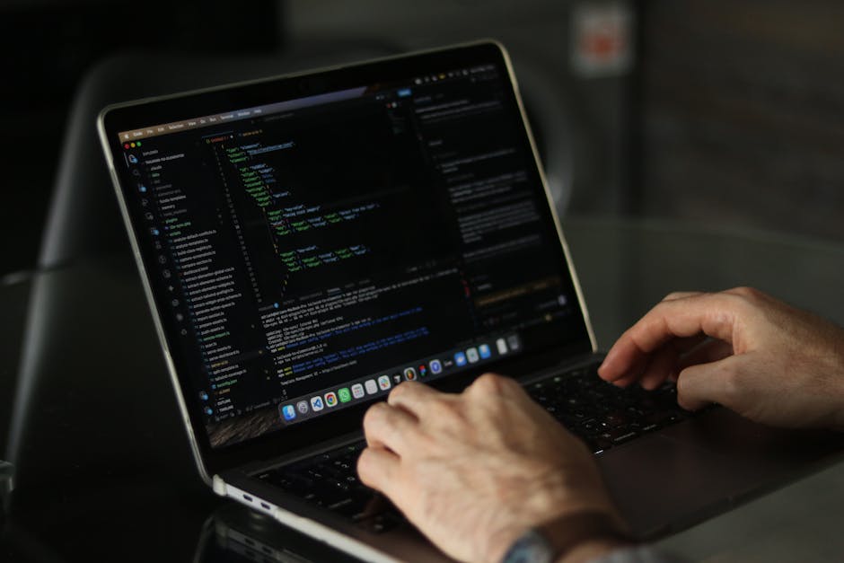 A computer screen displaying a code editor with HTML and CSS files open, showing lines of code for webpage structure and styling. The screen is in a dimly lit environment, with visible window titles i